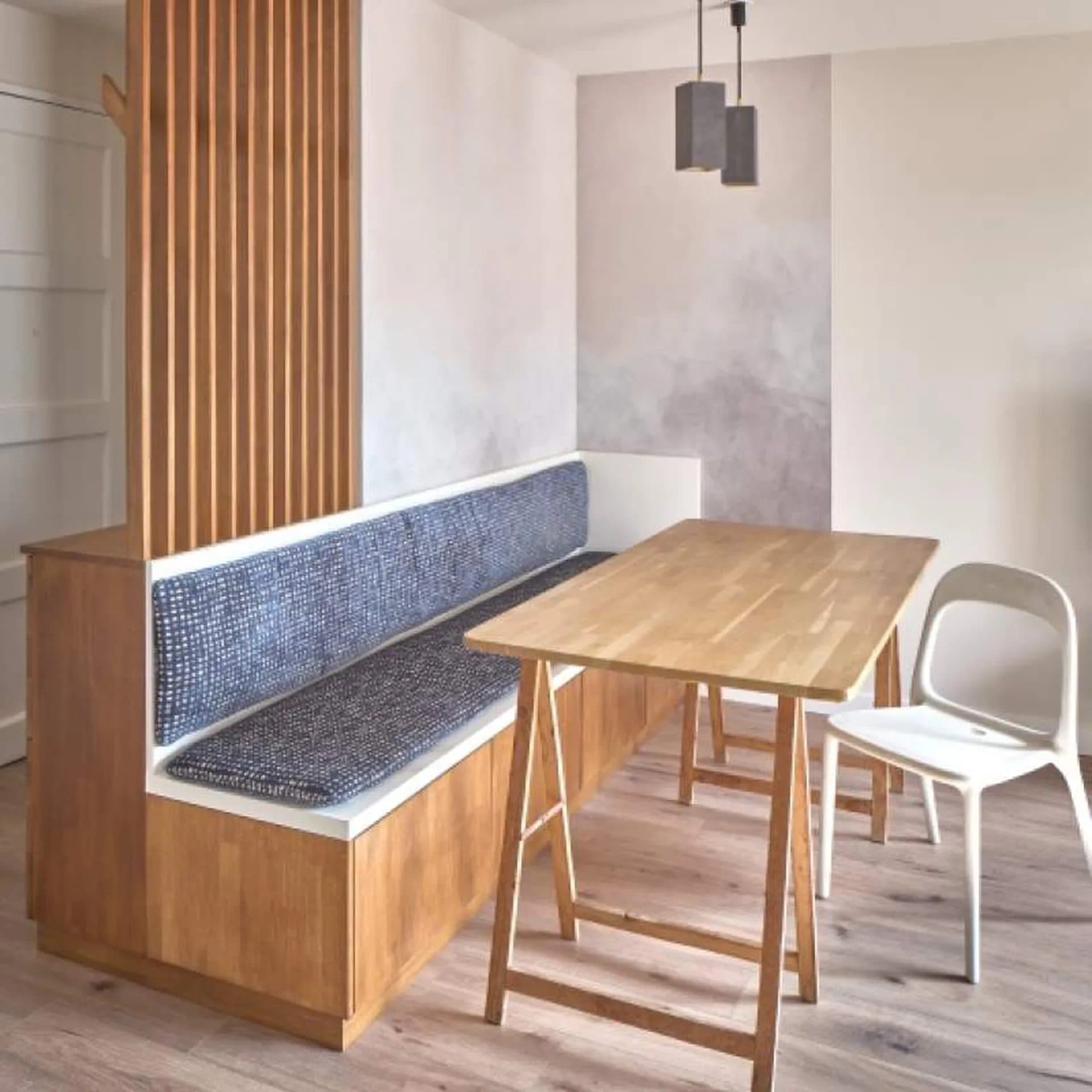 Banquette sur mesure en bois clair et assise textile, table de repas adossée
