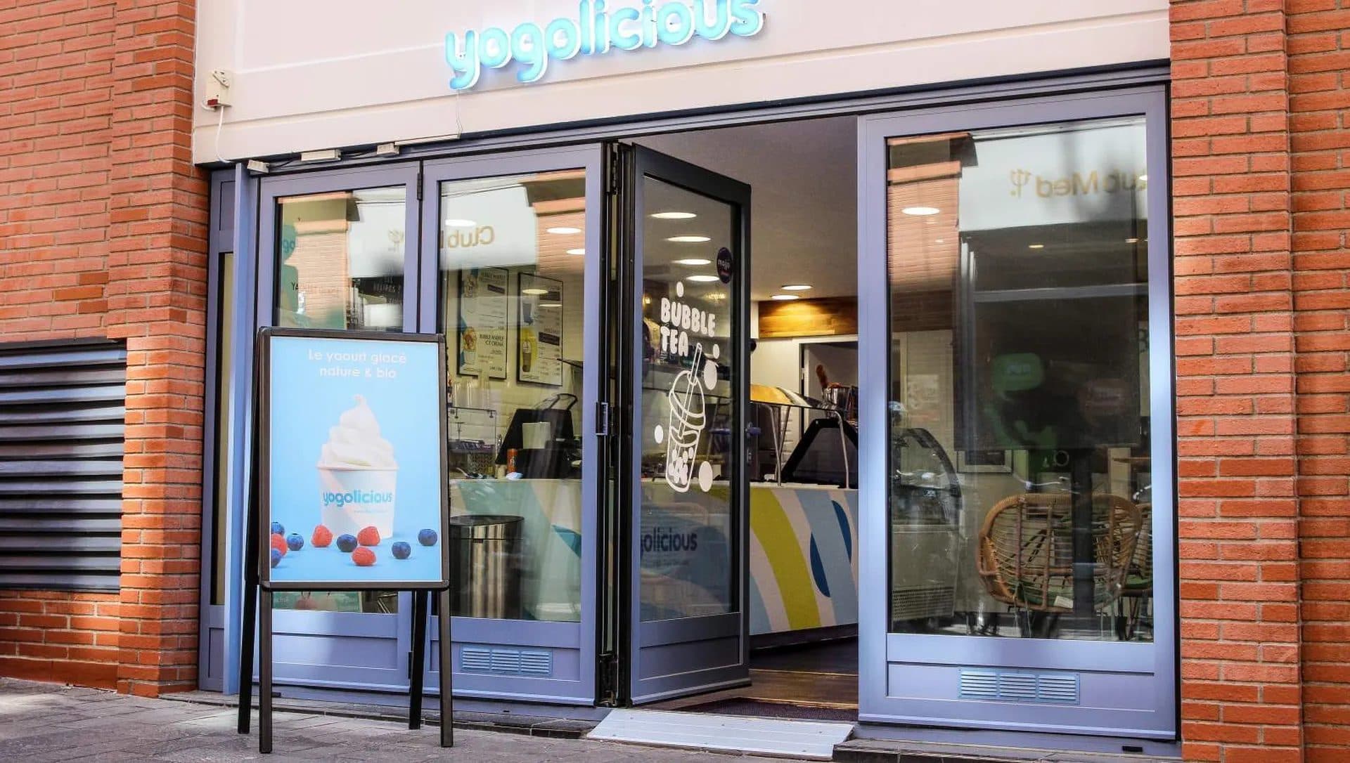 Devanture bleue de la boutique en façade de brique toulousaine