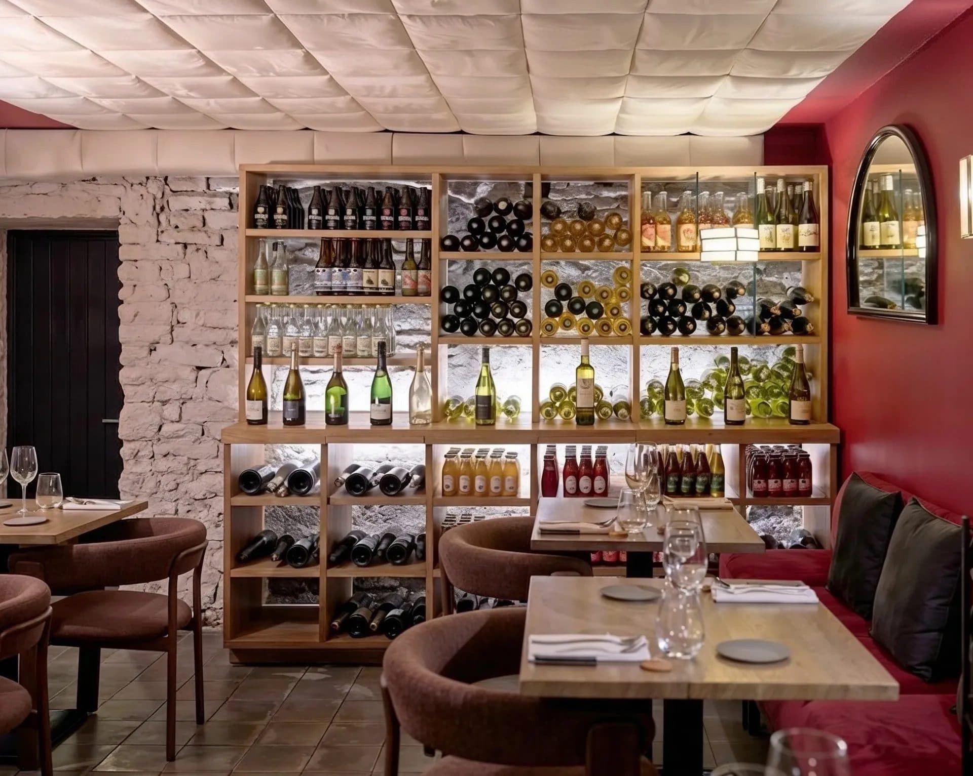 Espace en sous-sol autour de la cave à vin, mur rouge et casiers à bouteilles